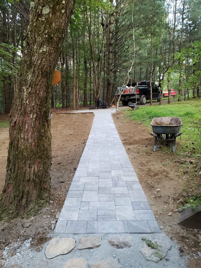 Paver walkway through wooded property